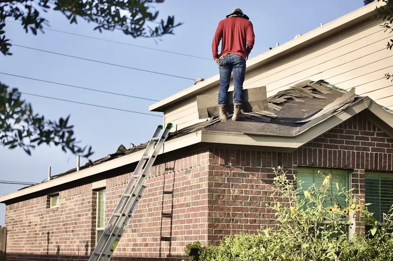 Professional roofer working on a residential roof in Wellesley
